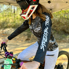 Load image into Gallery viewer, Womens black camo long sleeve Jersey. Made by Shredding Trails. Contours seamlessly around body armour like a glove. Proudly manufactured in Australia from recycled plastic bottles.