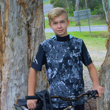 Load image into Gallery viewer, Kai Pyyvaara wearing our short sleeve black camo jersey . Available in youth sizes and made in Australia from recycled plastic.