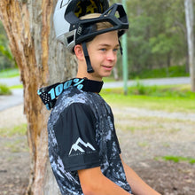 Load image into Gallery viewer, Kai Pyyvaara wearing our short sleeve black camo jersey . Available in youth sizes and made in Australia from recycled plastic.
